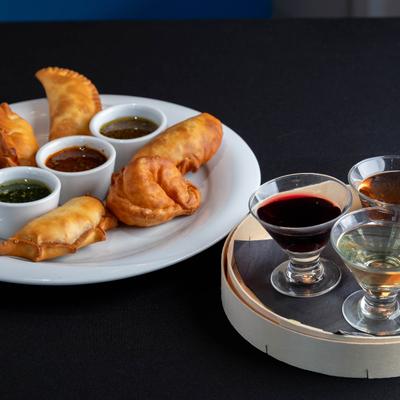 Served empanadas, various dips, and beverages.