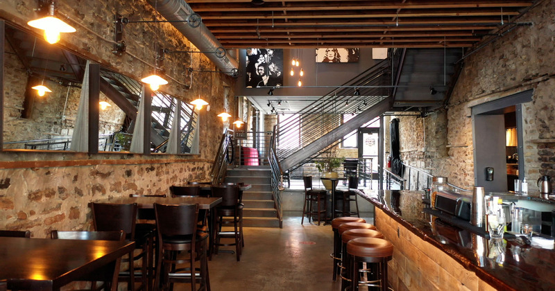 Restaurant interior, tables for four and a bar area on the right