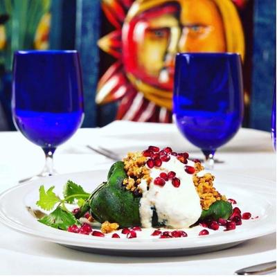 Stuffed green pepper, topped with cream, and pomegranate.