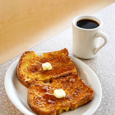 French toast served with butter and a cup of black coffee.