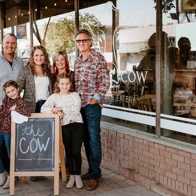 Owners' family standing next to The Cow board sign outside