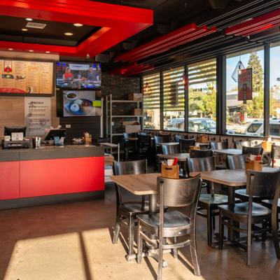 Food counter on left, diner area on right, tables, chairs.