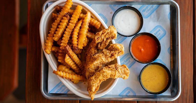 Crispy chicken tenders with crinkle-cut fries, ranch, ketchup, and honey mustard