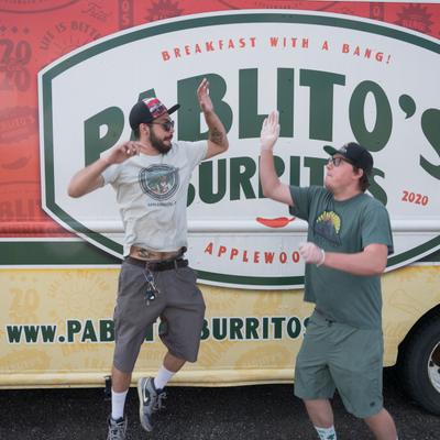 Exterior, owners jumping to hello slap in front the sign on a truck.