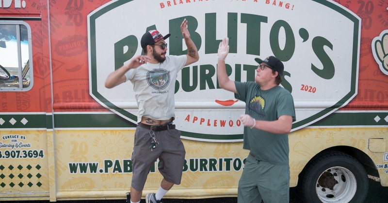 Exterior, owners jumping to hello slap in front the sign on a truck
