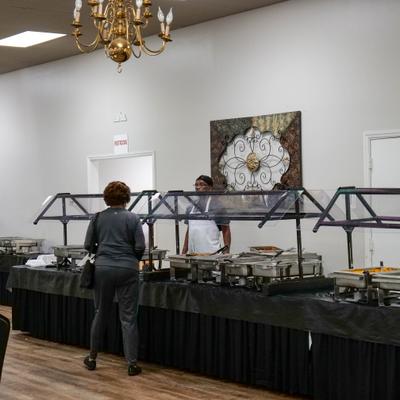 Person being served food from the buffet counter.