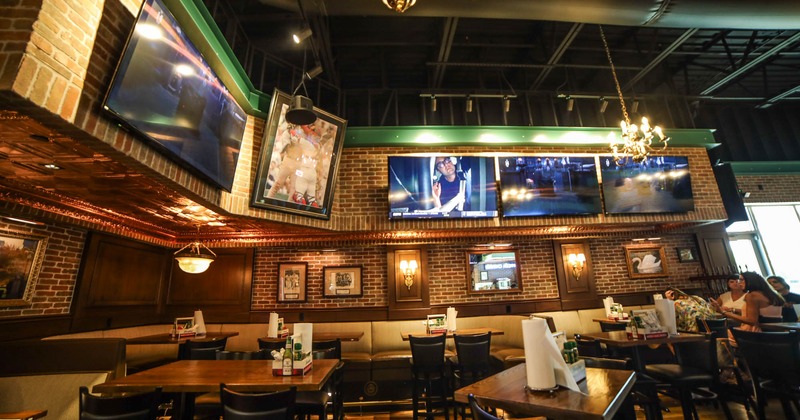 Tables, and booths, large TV screens on the walls above