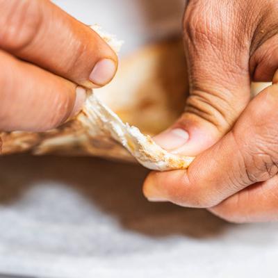 Hands pulling apart warm flatbread.