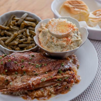 Baked chicken with gravy, creamy potato salad, and green beans.
