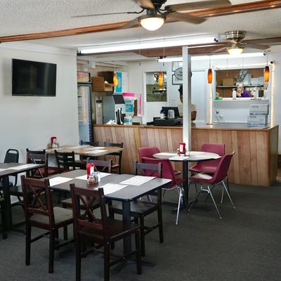 Interior with wooden tables, chairs, and counter service area.