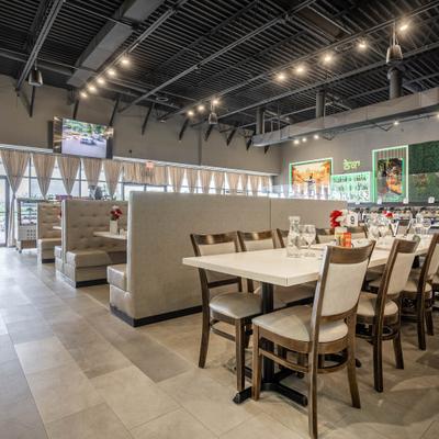 Modern restaurant interior featuring tables, booths, and buffet counters.