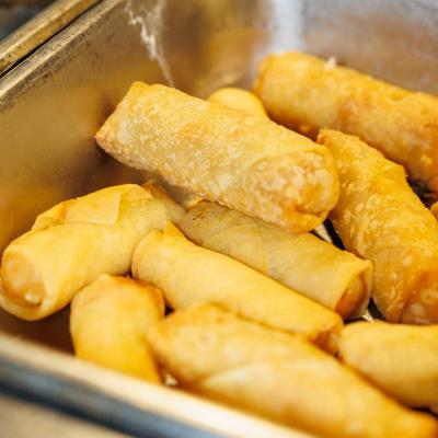 Fried spring rolls in a metal tray.