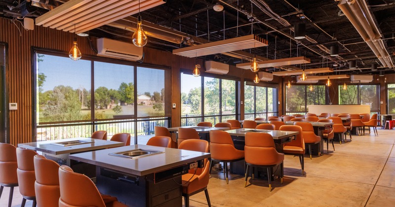 Interior dining area with wooden paneling and orange upholstered chairs