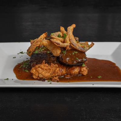 Braised short rib served on a cheesy polenta cake with demi-glace.