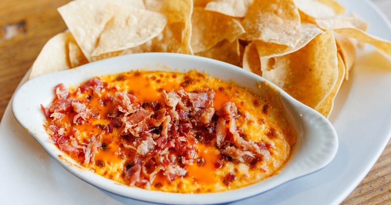Hot Pimento Cheese Dip topped with bacon and served with tortilla chips
