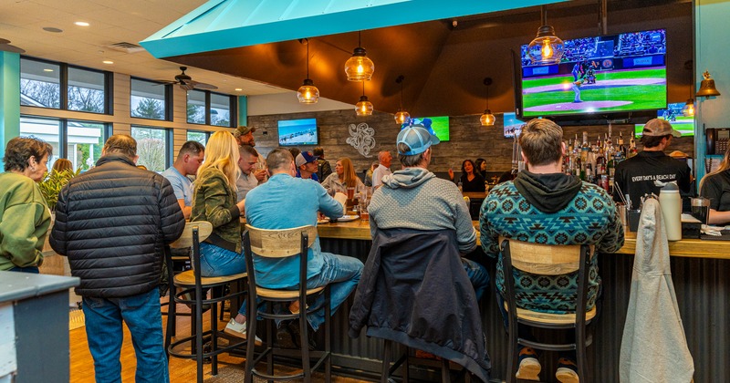 Bar, people seating around, tv screen above