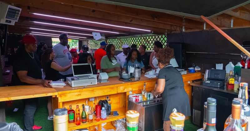 People ordering drinks at a busy outdoor bar