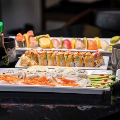 Assortiment of sushi rolls and sashimi served on the table.