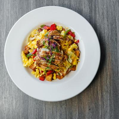 Breakfast bowl with scrambled eggs, grilled chicken, home fries, and bell peppers.