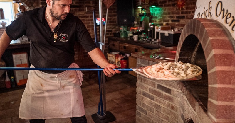 Chef placing a pizza in the oven