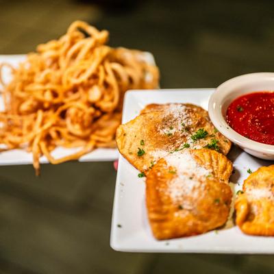 Fried ravioli with marinara on the plate, and spaghetti plate.