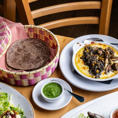 Oaxacan cheese dip topped with mushrooms and corn served with blue corn tortillas and green sauce.
