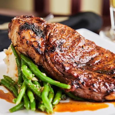 Bone In Ribeye with green beans and mashed potatoes, close up
