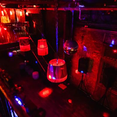 Vibrant red and blue lights illuminate a nightclub, setting the mood for a lively evening.