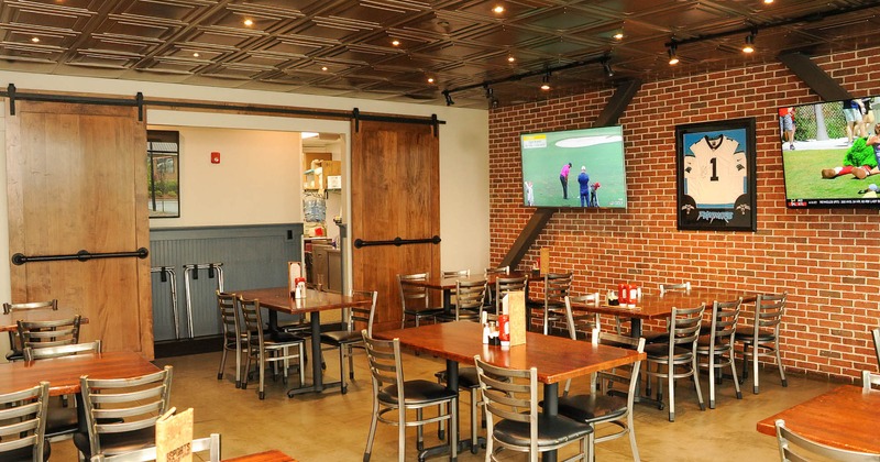 Interior, dining area, tables and chairs, large wall TV screens