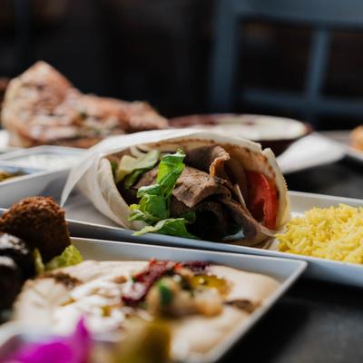 Gyro wrap surrounded by other dishes.