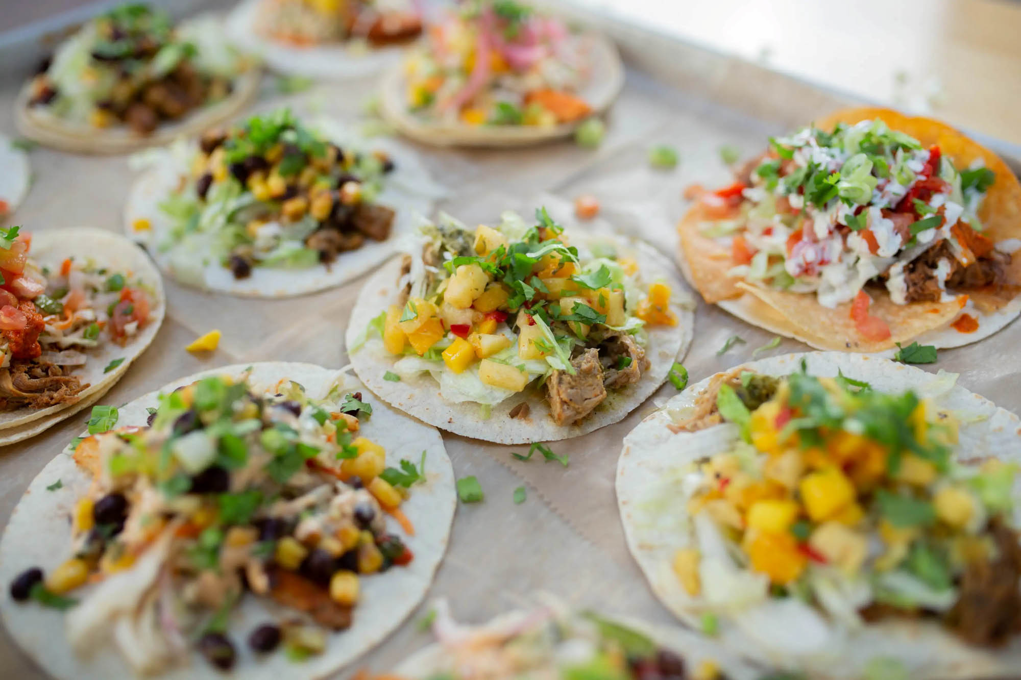 Assorted open-faced tacos with various toppings