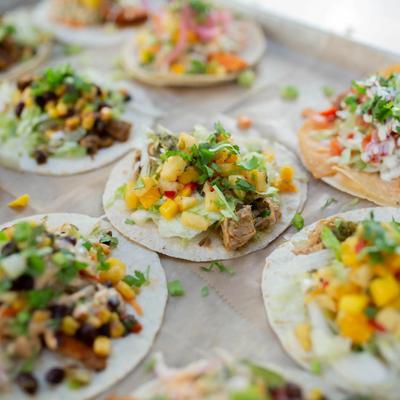 Assorted open-faced tacos with various toppings.