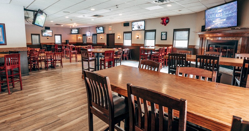 Interior, wooden furniture, TVs, framed artwork, and a rear door with signage