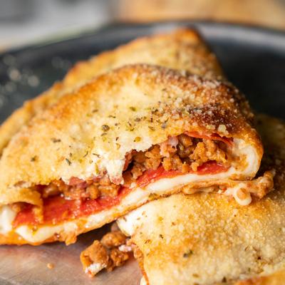 Cheesy calzone with ground meat, pepperoni, and tomato sauce.