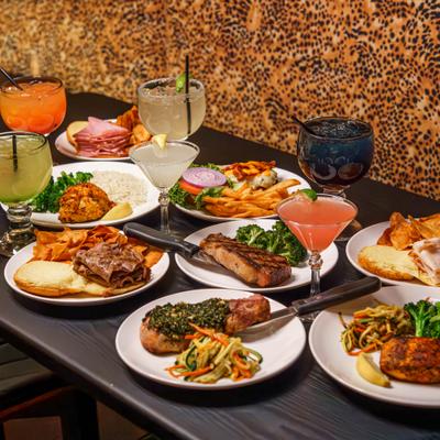 Assorted dishes and cocktails arranged on a dark table.