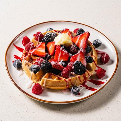 Waffle topped with mixed berries and sweet drizzle.