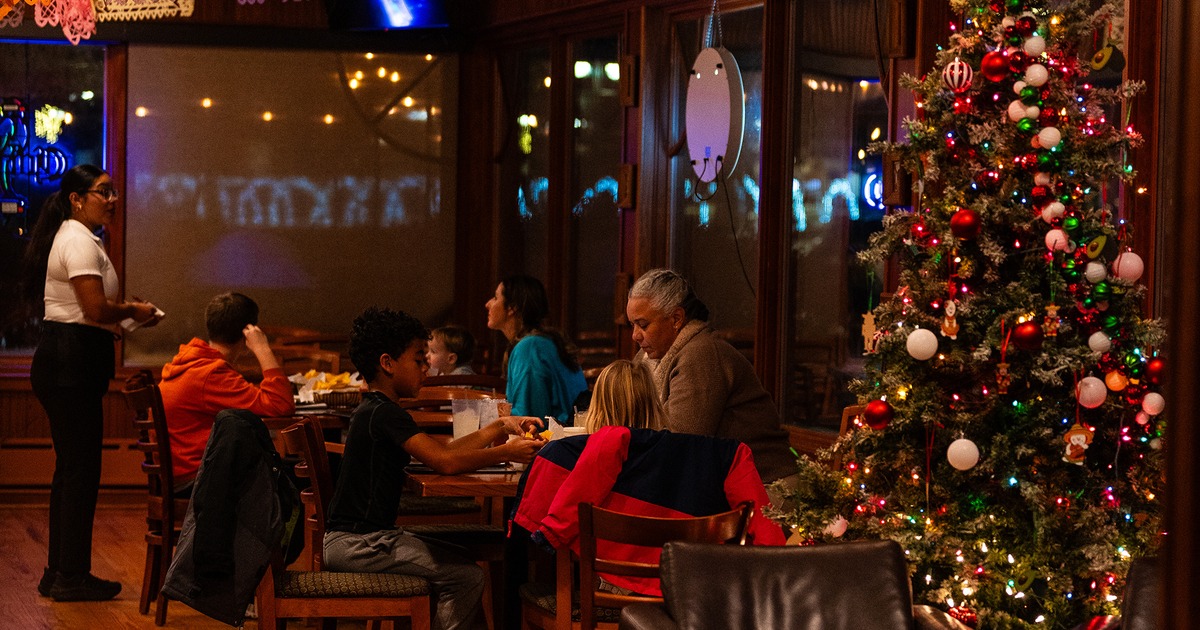 Interior dining area with guests enjoying their food, Christmas tree on the right side