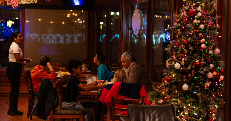 Interior dining area with guests enjoying their food, Christmas tree on the right side