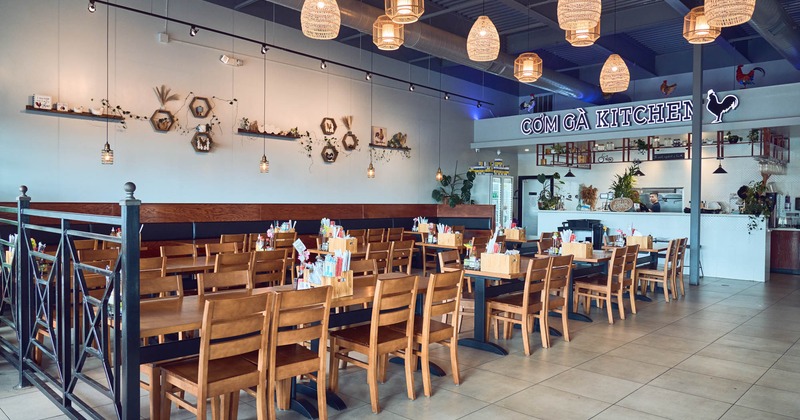 Interior, dining area, tables and chairs ready for guests, checkout counter in the back