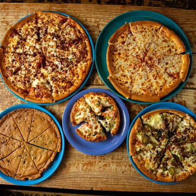 Various pizzas on a table.