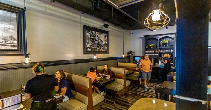 Interior, dining booths with guests dining, staff in action