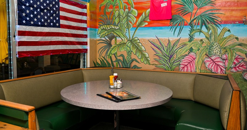 A large upholstered dining booth with round table