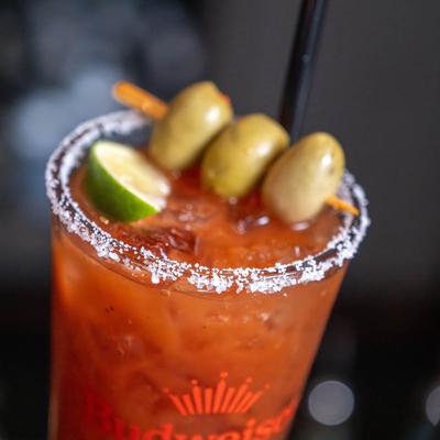 Bloody Mary with salted rim, olives and lime, close u.