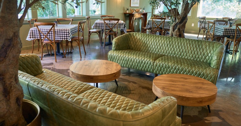 Interior, green leather sofas with round wooden table