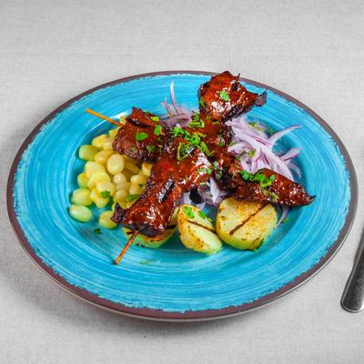 Marinated grilled beef heart served on top of potatoes, sweet corn and red onion.
