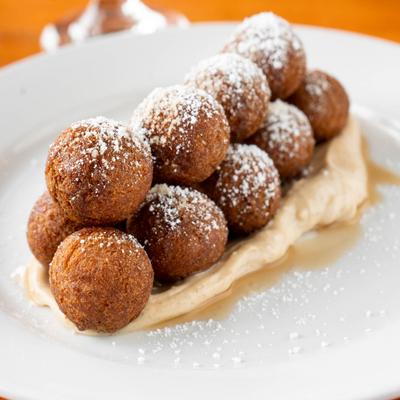 Churro donut holes dusted with powdered sugar.