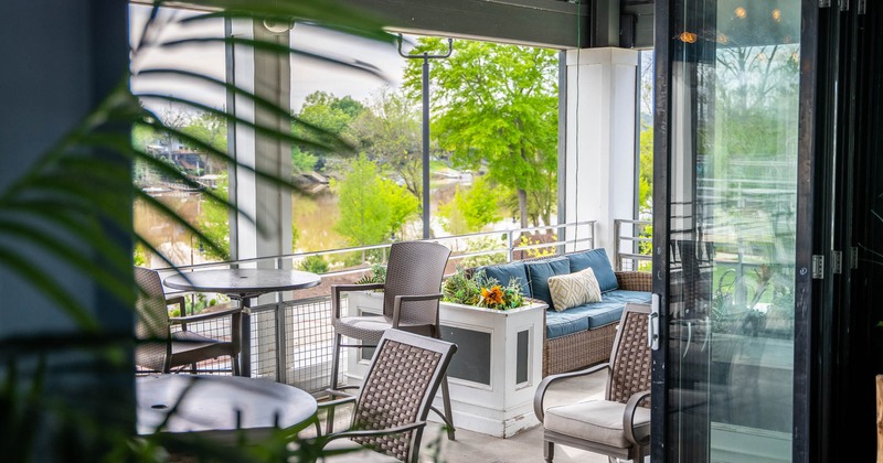 Interior, balcony seating area with tables and sofas