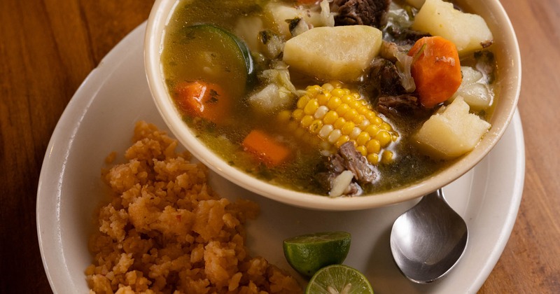 Mexican beef and vegetable soup served alongside rice