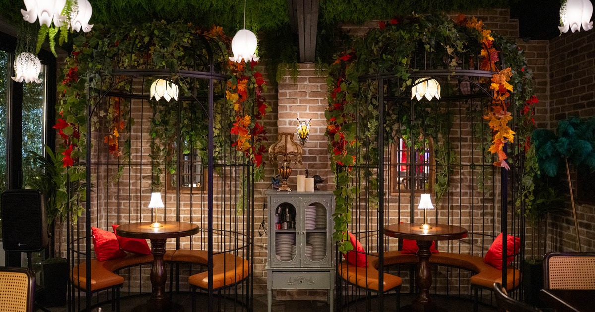 Interior, dining area, bird cage seating booths with floral decoration, plate cabinet