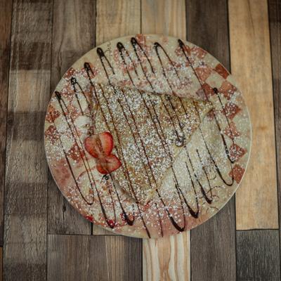 Simply nutella crepe drizzled with chocolate and garnished with strawberry slices.